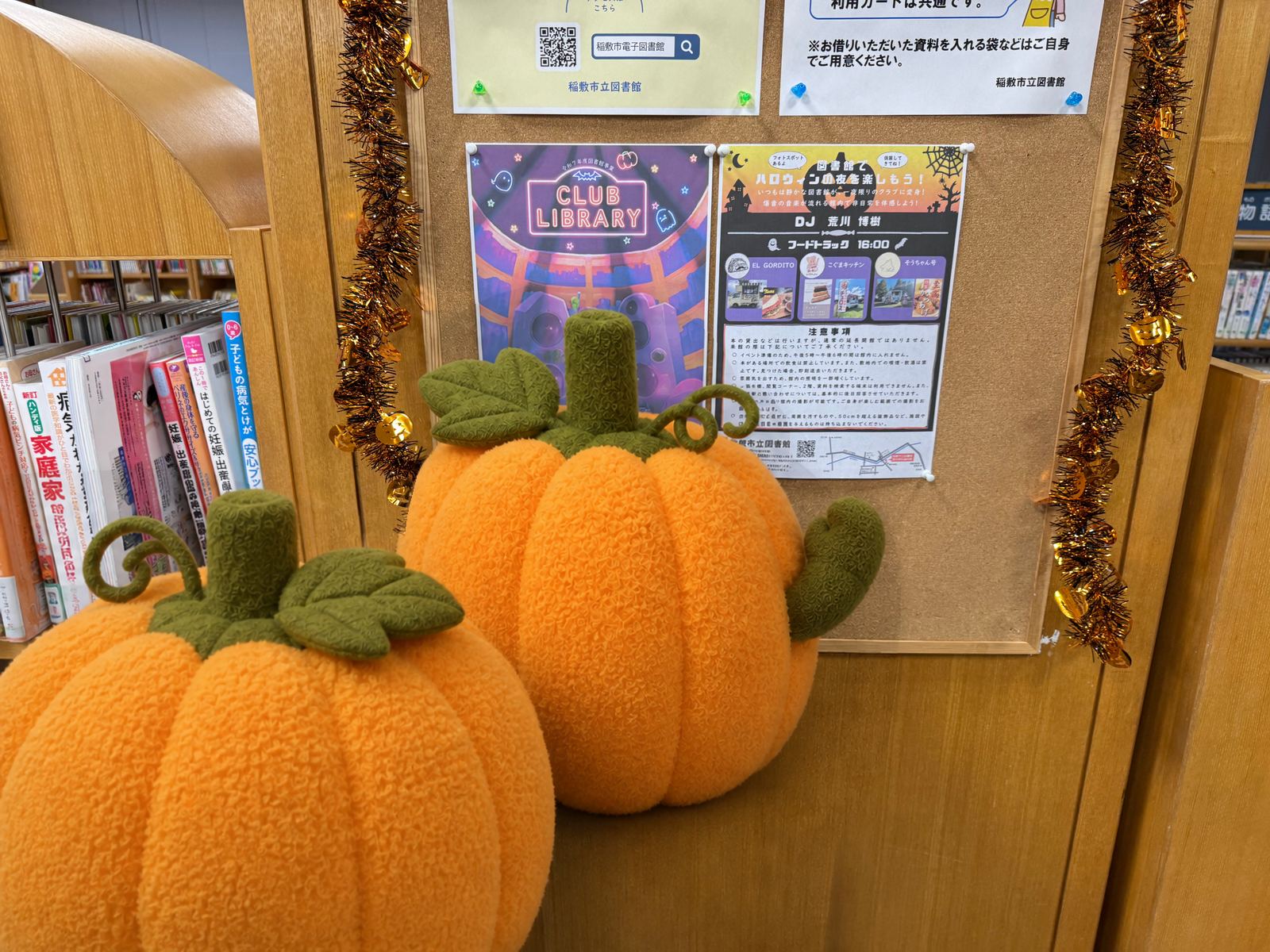 CLUB LIBRARYとフードトラックの案内が掲示された館内。手前の人物はかぼちゃのマスコットに置換