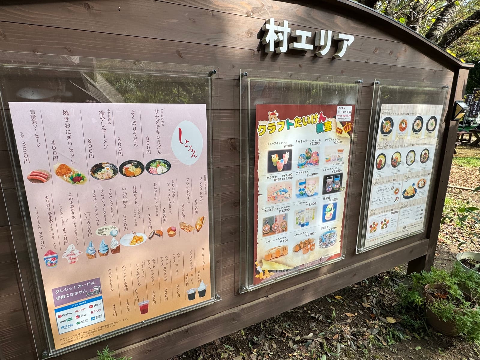 村エリアに掲示された食事とクラフト体験の案内